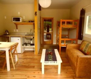 una sala de estar con un sofá y una mesa en Pinocha Point Bungalows, en La Paloma