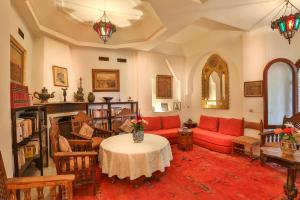 een woonkamer met een rode bank en een tafel bij Riad Dar El Assafir in Marrakesh