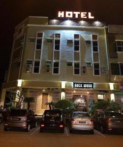 a hotel with cars parked in front of it at night at Rock Wood Hotel in Sungai Petani