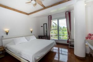 Lanterna Hotel Boracay في بوراكاي: غرفة نوم بسرير ابيض ونافذة