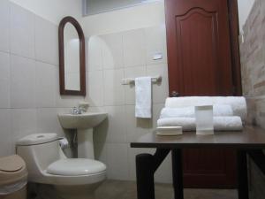 a bathroom with a toilet and a sink at El Cardenal Hotel in Loja