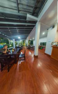 a large room with wooden floors and tables and chairs at Morakot Lanta Resort in Ko Lanta