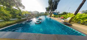 Morakot Lanta Resort في كو لانتا: مسبح فيه شخص في الماء