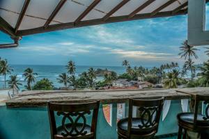 a bar with chairs and a view of the ocean at Resort Deepika Mirissa in Mirissa