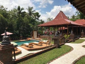 a resort with a swimming pool and a gazebo at Rumah Dharma 2 Riverside in Borobudur