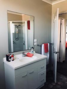 uma casa de banho com um lavatório e um espelho em Amberlea Cottages em Hokitika