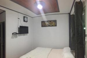 a bedroom with a bed and a tv on the wall at Moat View in Sukhothai