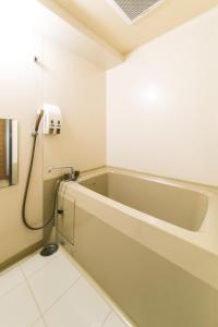 a bathroom with a bath tub in a room at Hotel Crystal Palace in Hitachinaka