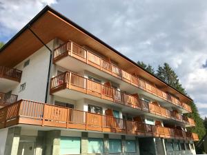 un edificio de apartamentos con balcones de madera en Appartamento Campiglio, en Madonna di Campiglio
