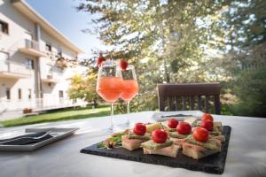 a table with a plate of food and two wine glasses at Draconerium Hotel in Dronero
