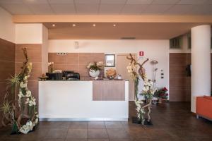 a lobby with a counter with flowers on it at Draconerium Hotel in Dronero