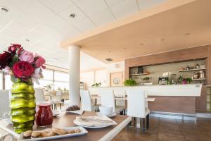 a dining room with a table with a vase of flowers at Draconerium Hotel in Dronero