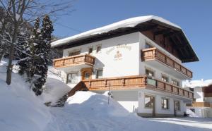 un bâtiment recouvert de neige avec un balcon dans l'établissement Haus Elisabeth, à Berwang