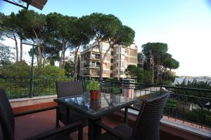 una mesa con sillas y una maceta en el balcón en Villa Arvalia Apartment, en Roma