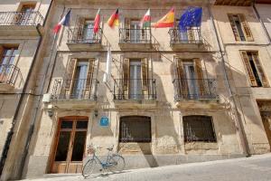 a bike parked in front of a building with flags at Sweet Home Salamanca in Salamanca