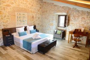 a bedroom with a bed and a desk and a chair at Hotel Molí de l'Escala in L'Escala