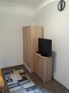 a television on a wooden cabinet in a room at Rooms Adrijana in Banja Luka