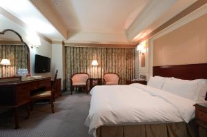 a hotel room with a bed and a desk and a computer at 爵起商務飯店 in Taoyuan +96 photos