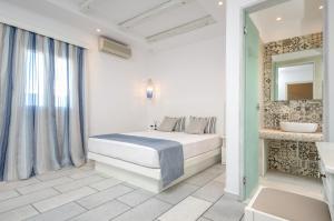a white bedroom with a bed and a mirror at Summer Dream 1 in Agios Prokopios +112 photos
