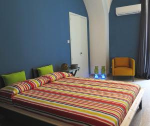 カターニアにあるLa Casa dei Coloriのカラフルなストライプ掛け布団付きのベッド1台