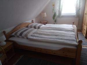 a wooden bed in a room with a window at Ferienwohnung Stanke in Büdelsdorf