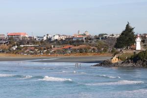 een uitzicht op een strand met een vuurtoren en de oceaan bij Pleasant View Bed & Breakfast in Timaru