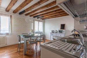 a kitchen with a sink and a table with chairs at Appartamento Calle Furlani in Venice