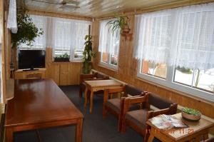 a living room with a table and chairs and windows at Pension Čertice in Pec pod Sněžkou