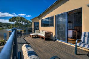 a large deck with furniture on a house at Mayakitana ~ Overlooking the golf course in Coles Bay