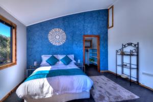 a blue bedroom with a bed and a window at Mayakitana ~ Overlooking the golf course in Coles Bay +8 photos
