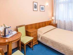 a hotel room with a bed and a desk and a table at Willa Biala Lilia Old Town in Gdańsk
