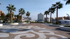 a large stone walkway with palm trees in a city at Portoverde Beach Apartments in Misano Adriatico