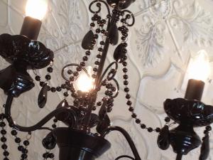 a black chandelier hanging from a ceiling with candles at Silverleaf Cottage in Rye