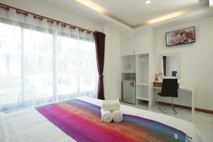 a bedroom with a large white bed with a rainbow blanket at Gusto House in Chiang Mai