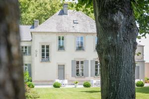 una vista exterior de una casa con un árbol en Le Petit Matin en Bayeux