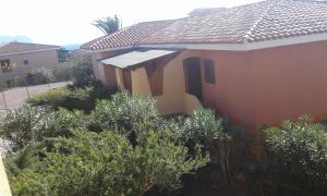a house with trees and bushes in front of it at Residence Spiaggia Bianca in Golfo Aranci