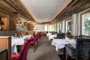 un ristorante con tavoli bianchi e sedie rosse di Natur- und Aktivresort Reiterhof ad Achenkirch