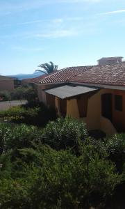 a house with a roof with bushes and trees at Residence Spiaggia Bianca in Golfo Aranci