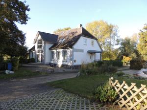 uma casa branca com uma cerca de madeira em frente em Haus Wiesenblick em Boltenhagen