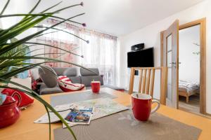 un salon avec une table et une plante dans l'établissement Apartment Saski Garden Marszalkowska street, à Varsovie