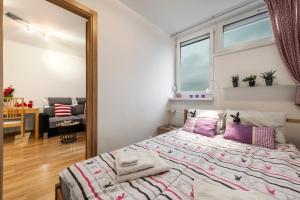 una camera da letto con un grande letto con cuscini viola di Apartment Saski Garden Marszalkowska street a Varsavia