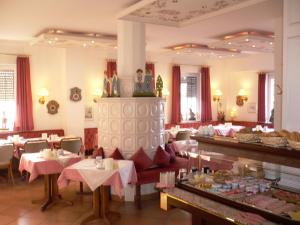 ein Restaurant mit Tischen und Stühlen in einem Zimmer in der Unterkunft Hotel Hubertus Hamacher in Willich