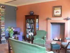 sala de estar con sofá, sillas y estante para libros en Casa Isabella, en Vaglio Serra