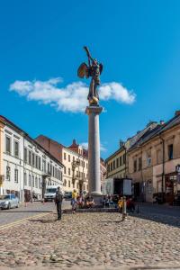 una estatua de una mujer sobre un pilar en una ciudad en Angel House Vilnius 38, en Vilna