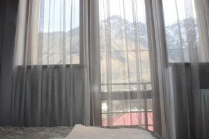 een slaapkamer met een raam met uitzicht op een berg bij Hotel Gergeti in Kazbegi