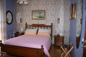 um quarto com uma cama com lençóis roxos e paredes azuis em A casa di Gianna B&B em Rieti