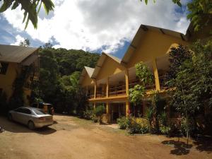 a house with a car parked in front of it at Pousada Serraninhos in Santa Leopoldina