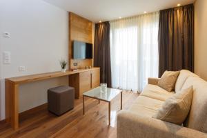 a living room with a couch and a table at Hotel Crown in Andermatt