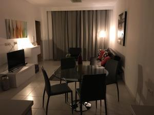 a living room with a glass table and chairs at Residencial Sabrina in Playas de Orihuela