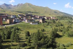 a town on a hill with mountains in the background at Appartamento San Bartolomeo in Passo del Tonale